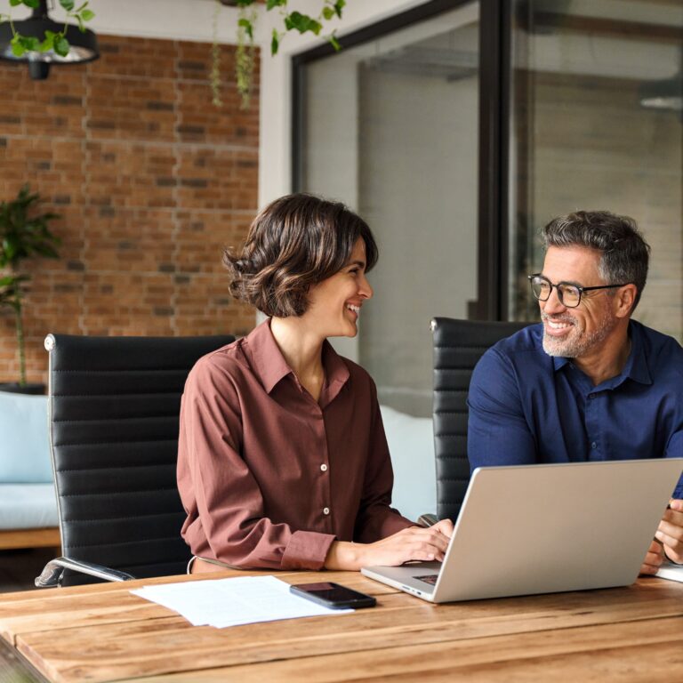 Ferienhaus-Management: Team arbeitet an Laptop, optimiert Vermietungsprozesse.