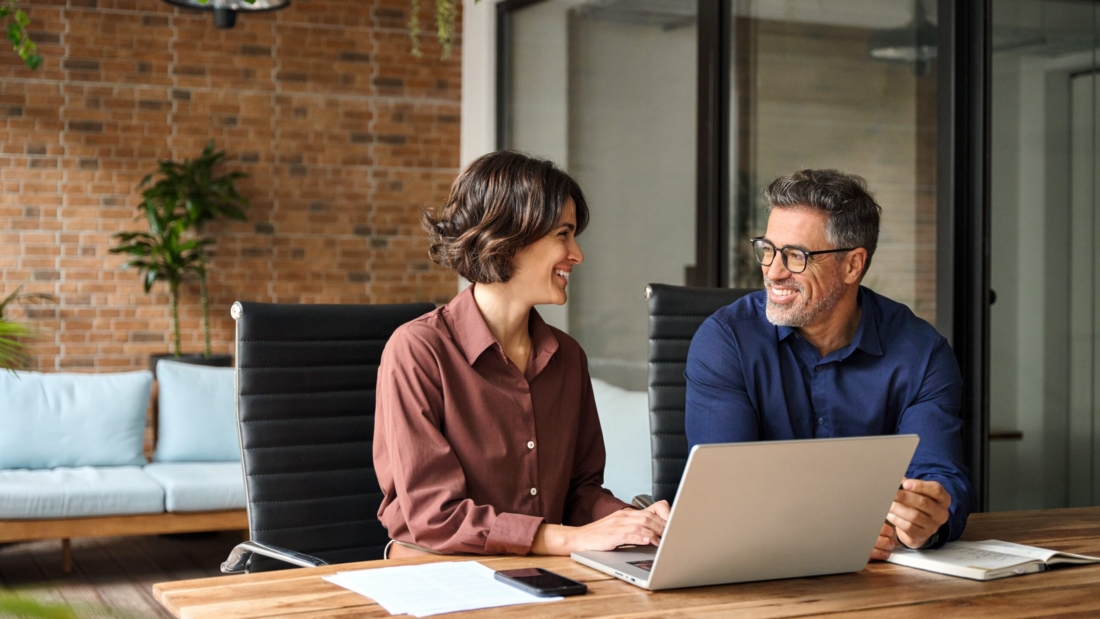 Ferienhaus-Management: Team arbeitet an Laptop, optimiert Vermietungsprozesse.