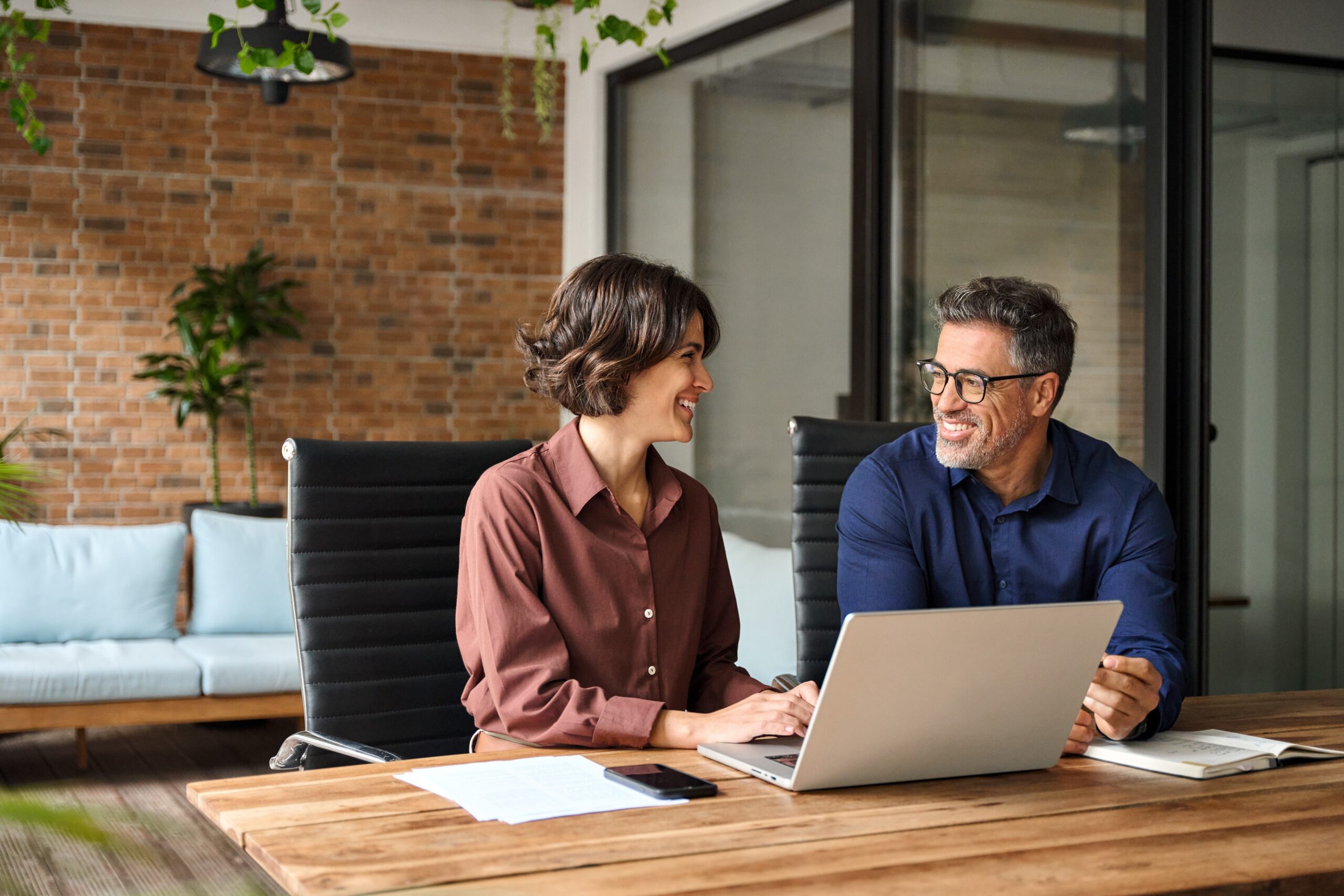 Ferienhaus-Management: Team arbeitet an Laptop, optimiert Vermietungsprozesse.